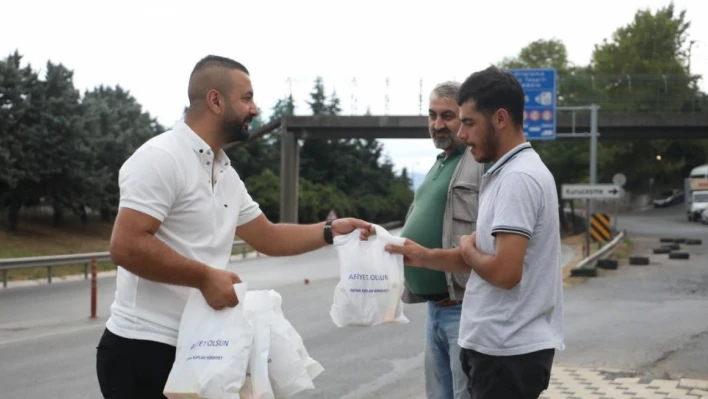 Servis bekleyen işçilere poğaça dağıtılıyor